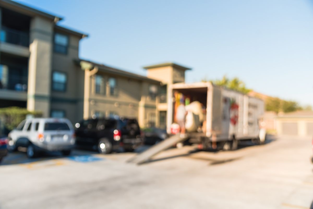 Blurred image mover carries mattress on loading ramp of moving truck for apartment relocation in Humble, Texas, USA. Relocate condominiums, homes, re-arranging furniture concept background.